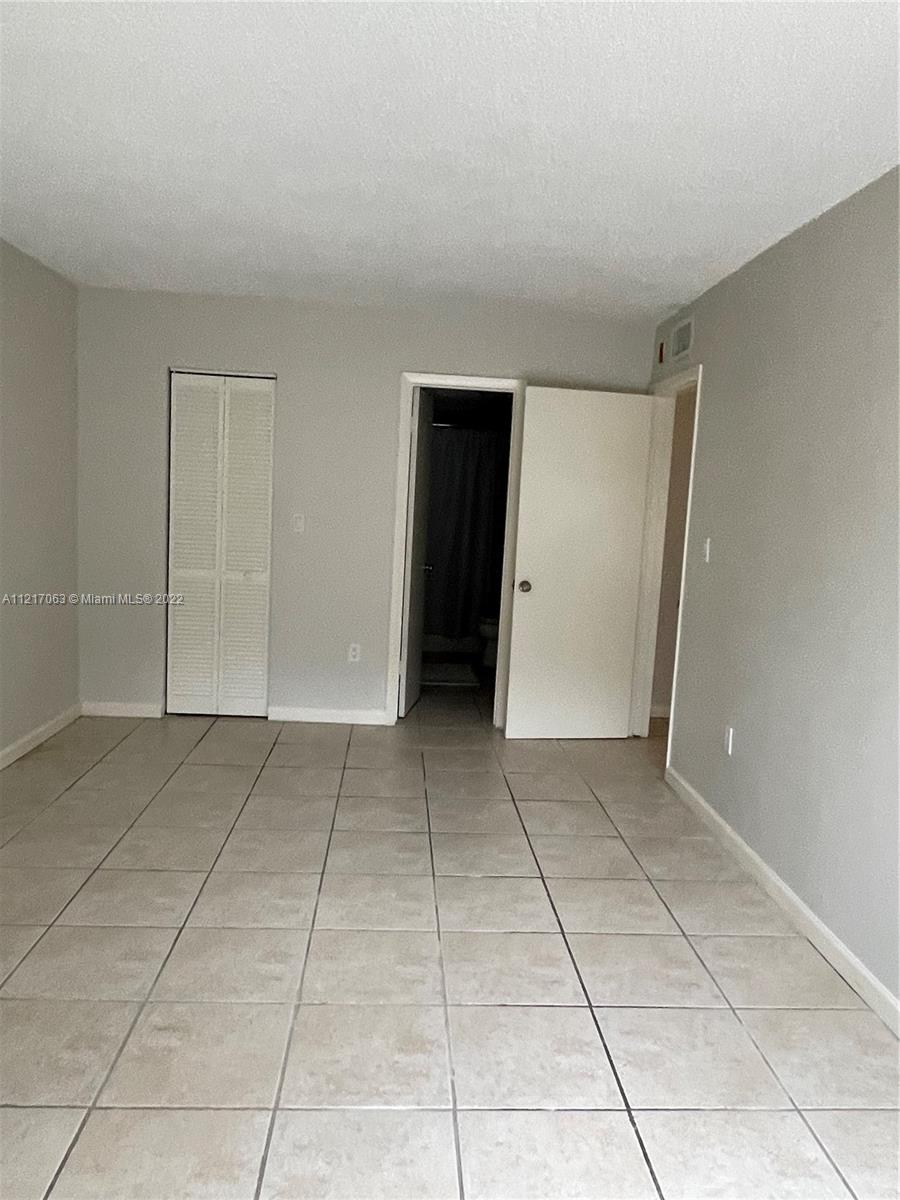9611 Southwest 77th Avenue, Unit 108A Miami, FL 33156 - Photo 9 of 12 a view of a livingroom with an empty space and closet area