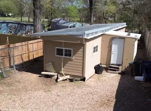 a view of a house with backyard and trees