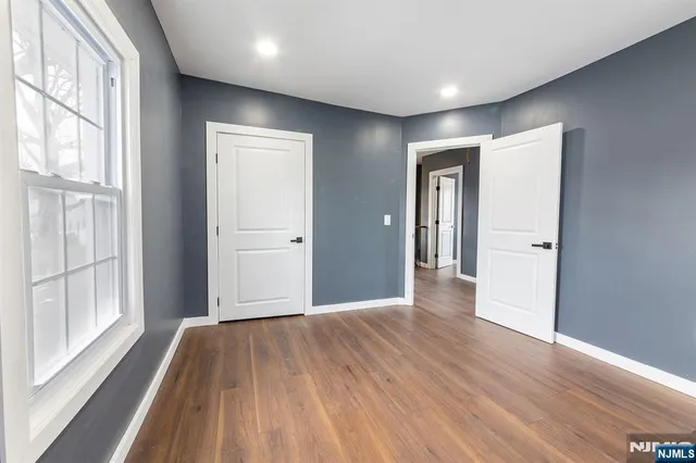 a view of hallway with a large window and wooden floor