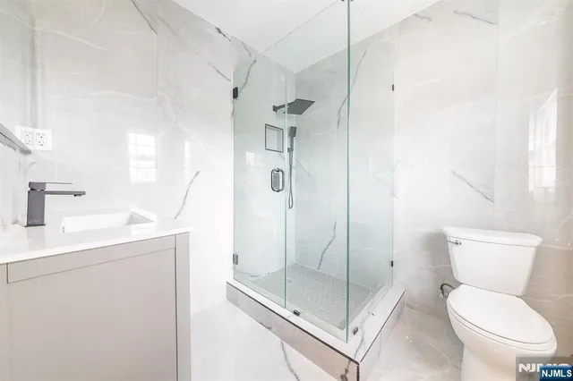 a bathroom with a shower a toilet and sink