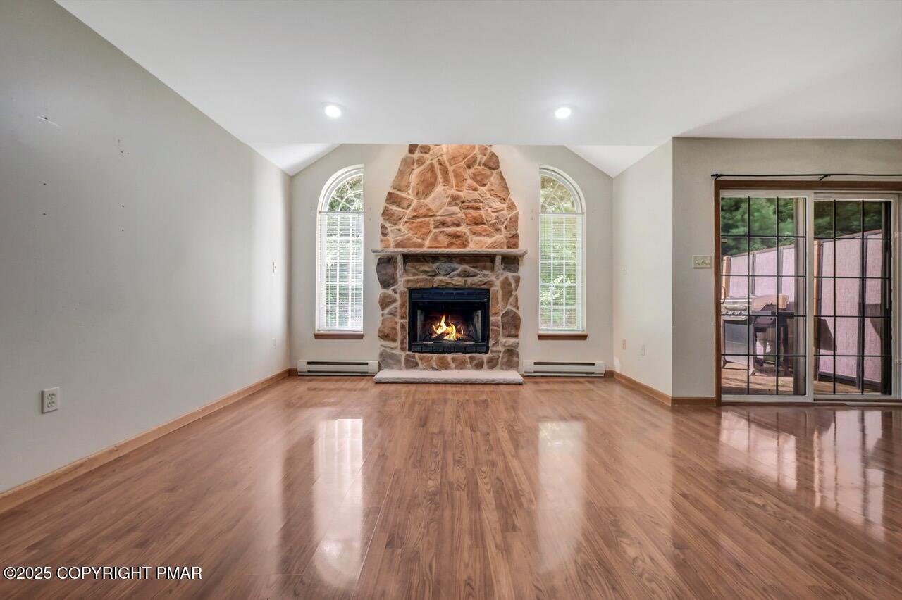 613 Country Acres Court Effort, PA 18330 - Photo 8 of 40 an empty room with wooden floor fireplace and windows