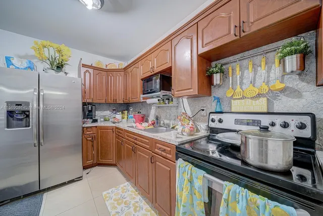 a kitchen with stainless steel appliances granite countertop a stove a sink dishwasher and a refrigerator