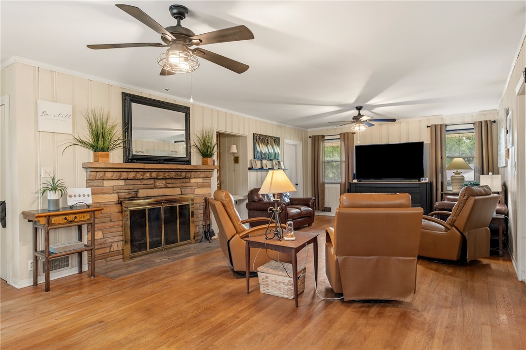 1105 Greenacres Anderson, SC 29621 - Photo 8 of 46 A welcoming living area featuring a stone fireplace and warm wood flooring throughout.