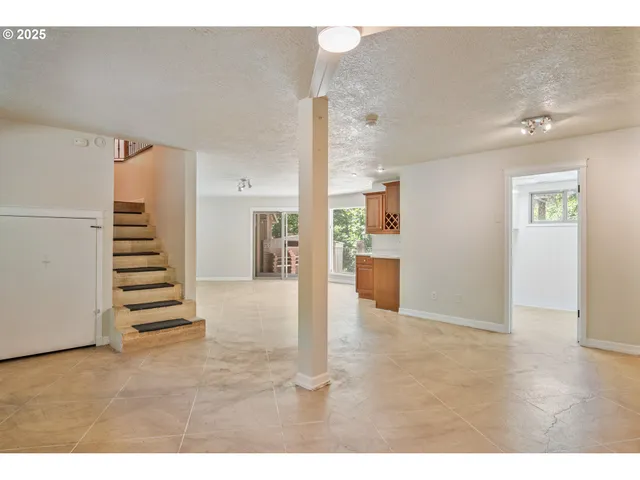 a view of a hallway with stairs and a living room