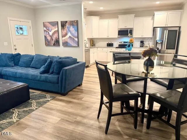 a view of kitchen with stainless steel appliances granite countertop a dining table and chairs