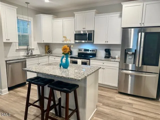 a kitchen with granite countertop white cabinets and stainless steel appliances