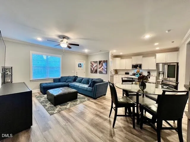 a living room with furniture a dining table and chairs with wooden floor