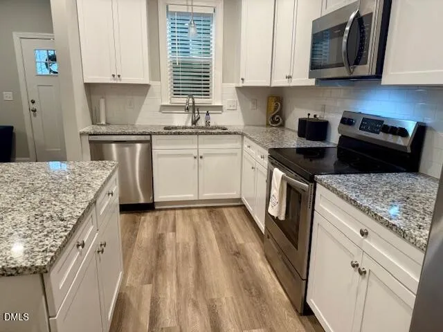 a kitchen with granite countertop a sink stove and cabinets