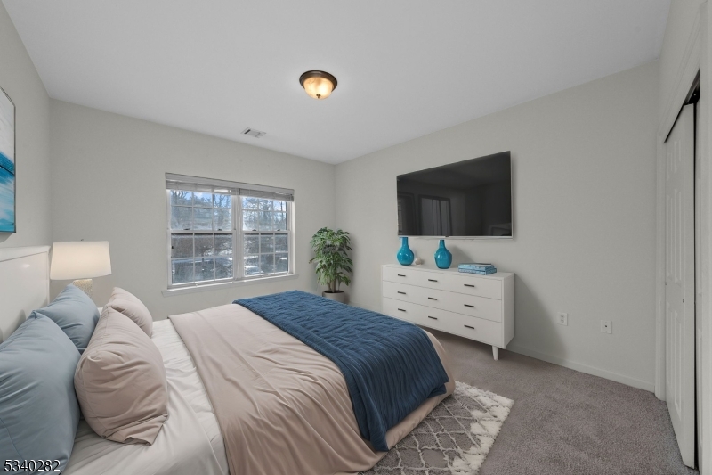 41 Park Drive, Unit 41 Clinton, NJ 08809 - Photo 24 of 38 a bedroom with a bed a large window and flat screen tv