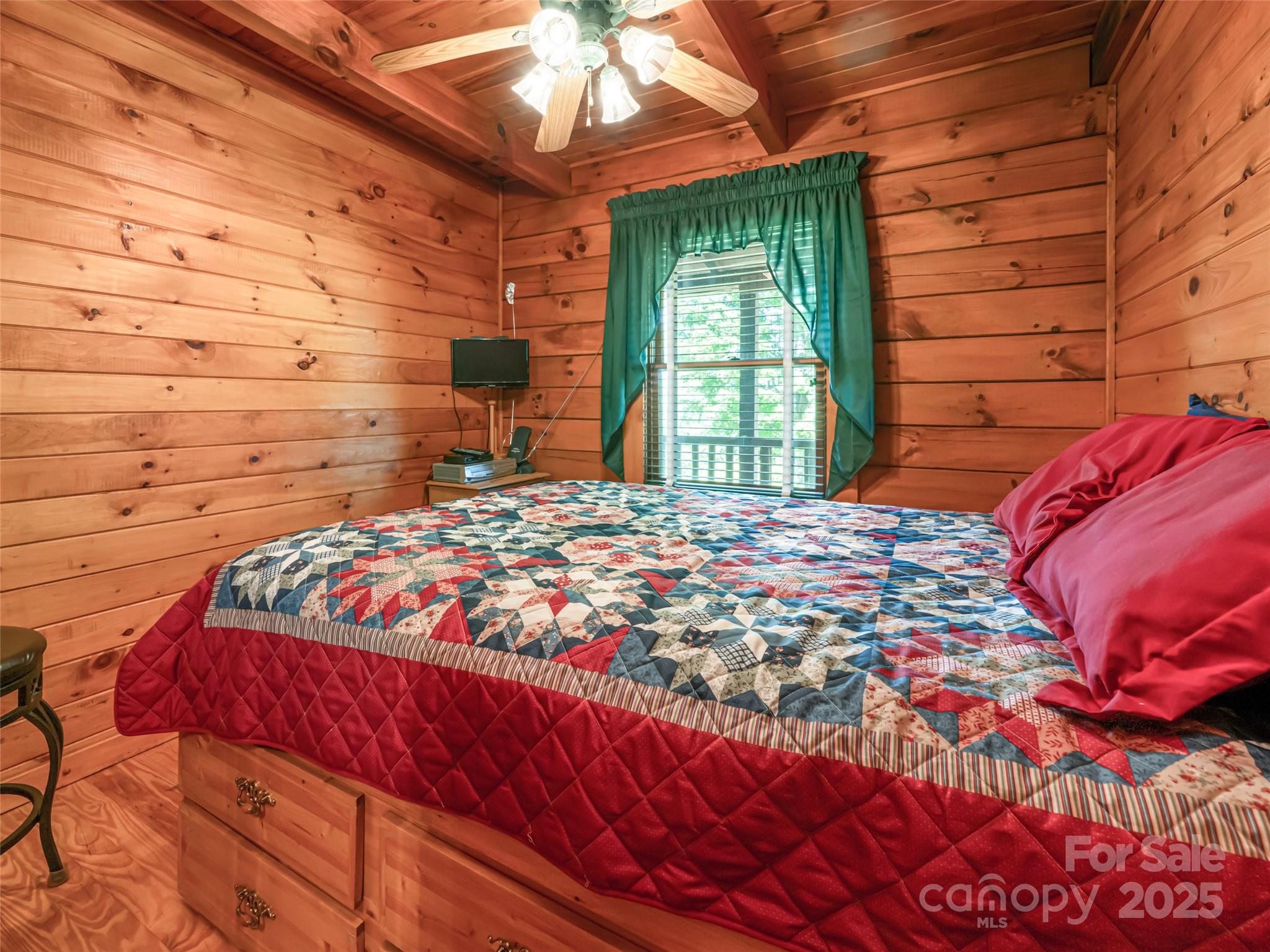 129 Melrose Lake Road Saluda, NC 28773 - Photo 19 of 48 a bed sitting in a bedroom next to a window