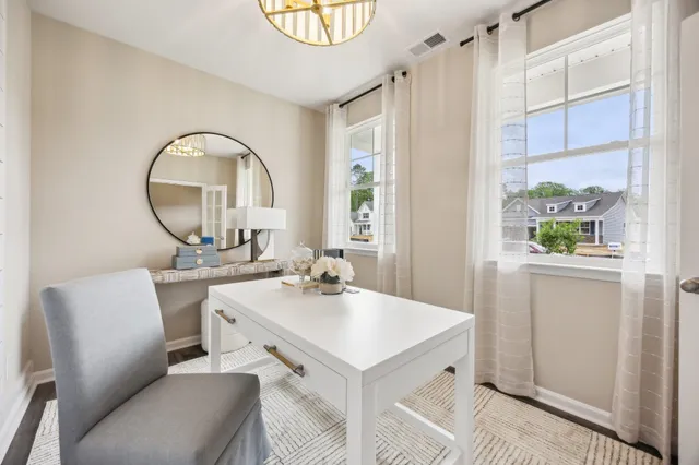 a room with a table chairs and a kitchen view