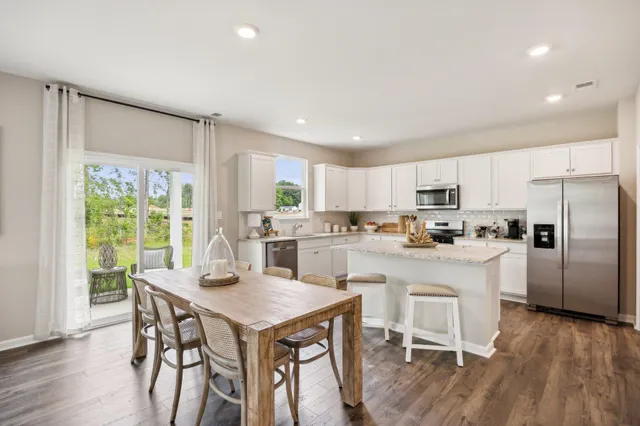a kitchen with a table chairs refrigerator and cabinets