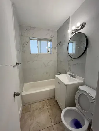 a view of empty room with kitchen and window