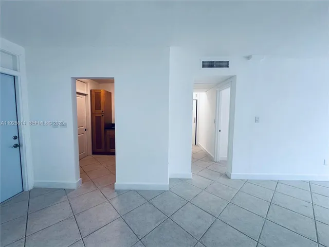 an empty room with a bathroom and mirror