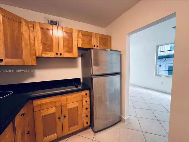 a kitchen with stainless steel appliances granite countertop a refrigerator and a stove