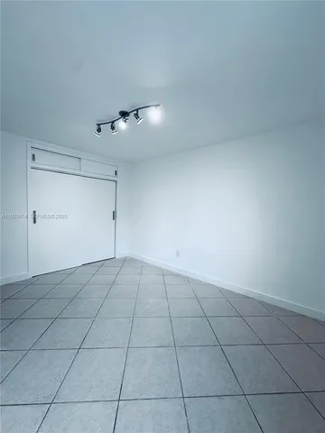 a view of an empty room and chandelier fan