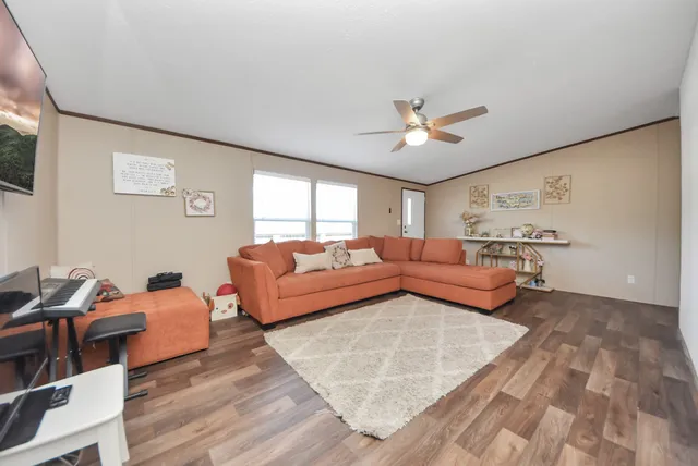 a living room with furniture a ceiling fan and a rug