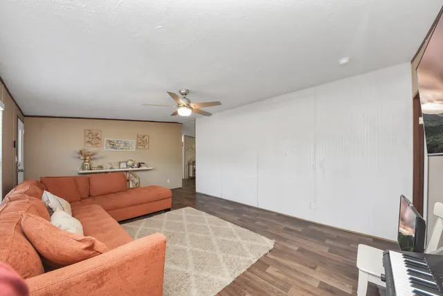 a living room with furniture and a ceiling fan