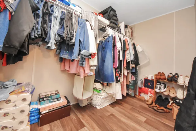 a view of walk in closet with clothes and shoes