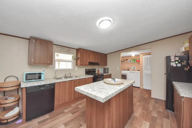 a kitchen with granite countertop a sink stove and cabinets