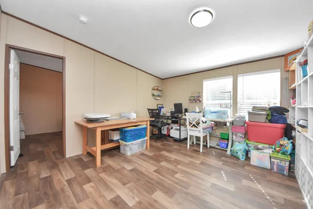 a view of a workspace with furniture and a window