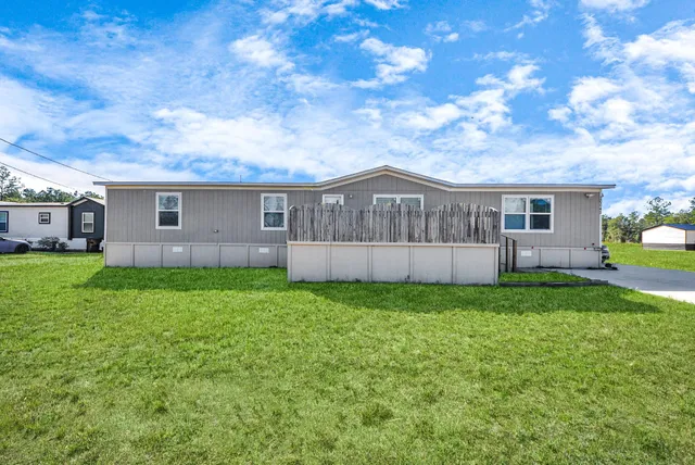 a view of a house with backyard and garden