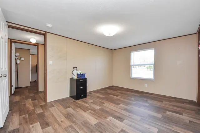 a view of a big room with wooden floor and a bathroom