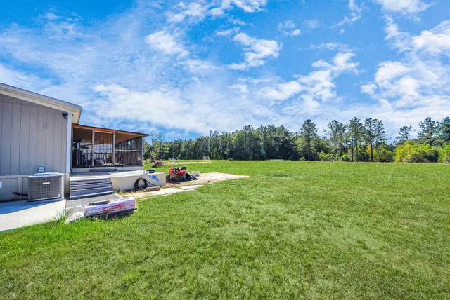 a view of a house with backyard and sitting area