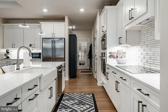 a kitchen with granite countertop a sink stove refrigerator and cabinets