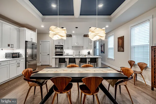 a dining room filled chandelier and wooden furniture