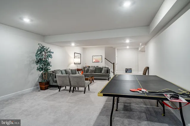 a living room with furniture pool table and a potted plant