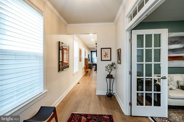 a view of a hallway with wooden floor and windows