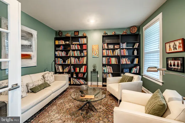 a living room with furniture and a book shelf