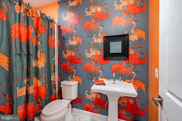 a bathroom with a sink a toilet and shower curtain