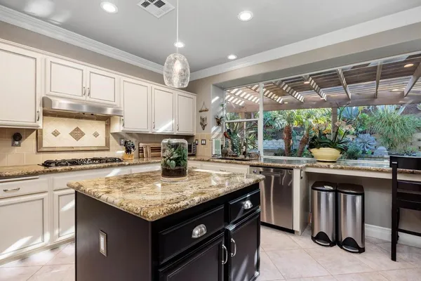 a kitchen with stainless steel appliances granite countertop a stove and cabinets