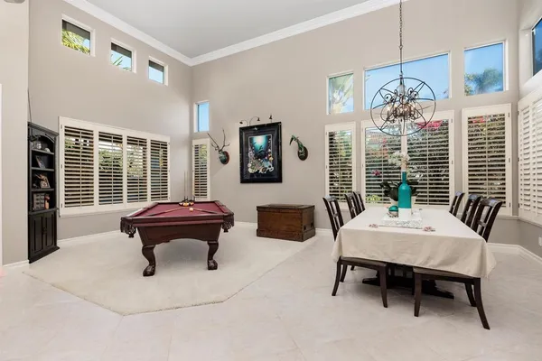 a room with pool table and two windows