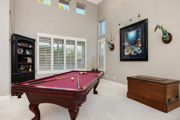 a room with pool table and windows