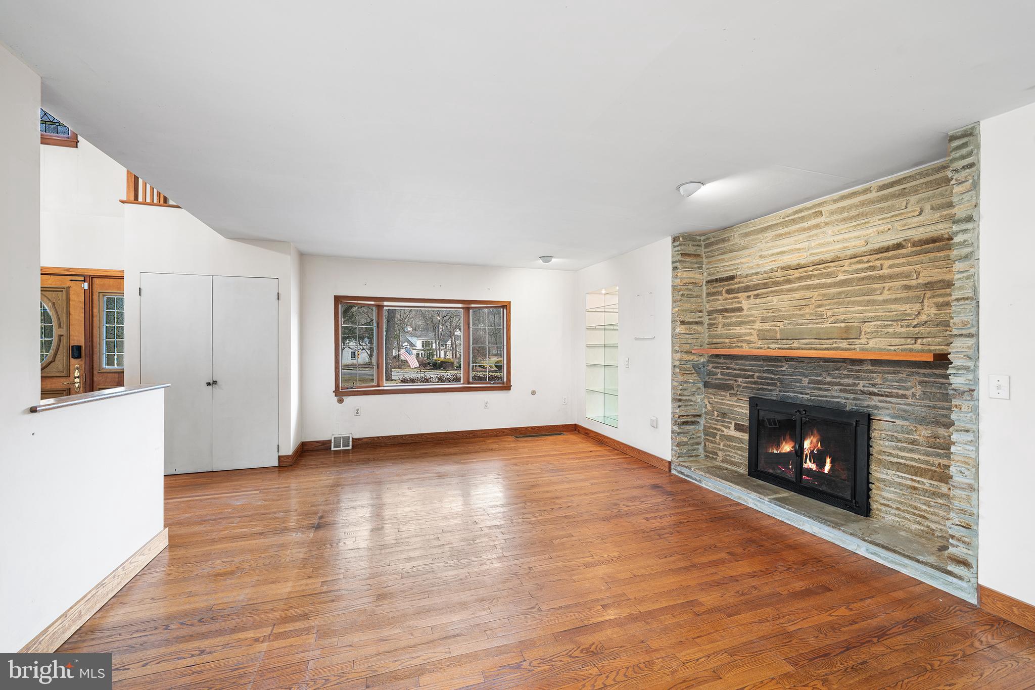 906 Hunt Road Newtown Square, PA 19073 - Photo 5 of 40 a view of an empty room with wooden floor fireplace and a window