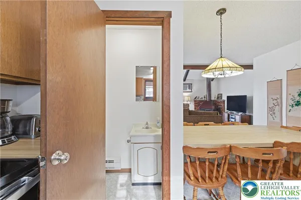 a dining room with wooden floor a chandelier a wooden table and chairs
