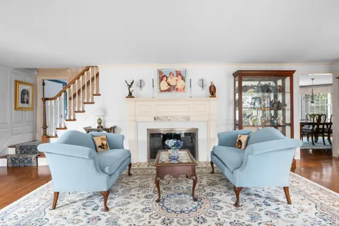 a living room with furniture a large window and a fireplace