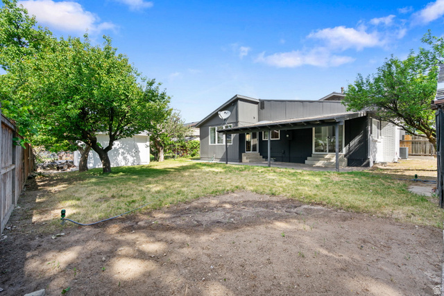 432 Calnette Drive Sandy, UT 84070 - Photo 43 of 48 Expansive backyard featuring mature trees, a privacy fence, and a covered patio