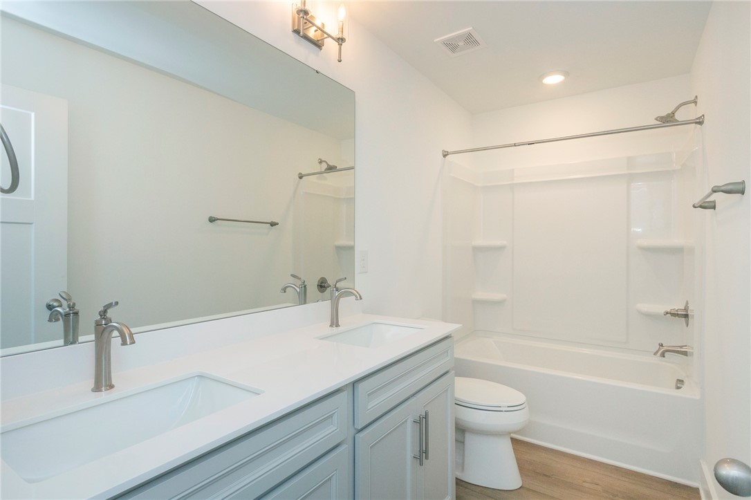 607 WH Kay Lane Anderson, SC 29621 - Photo 27 of 48 A well-appointed bathroom features a double vanity and a pristine tub with shower.