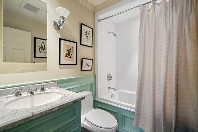 a bathroom with a granite countertop toilet sink and mirror