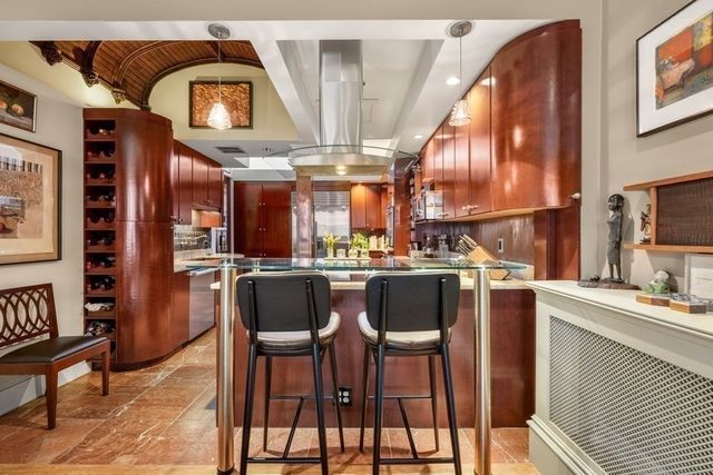 a kitchen with stainless steel appliances kitchen island granite countertop a table and chairs in it
