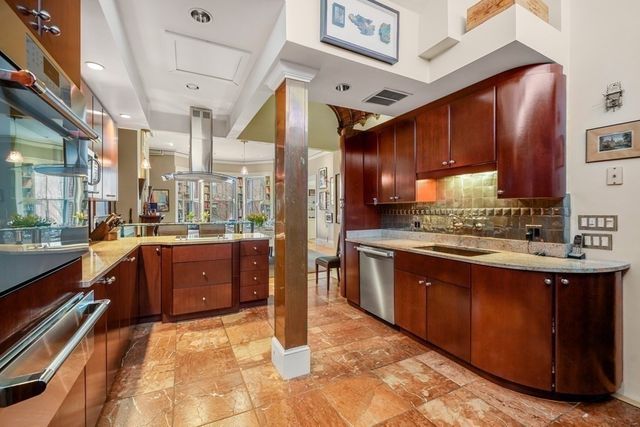 a large kitchen with stainless steel appliances wooden cabinets and a stove