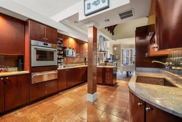 a kitchen with stainless steel appliances granite countertop wooden cabinets a sink and dishwasher