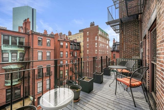 a view of a balcony with two chairs and a potted plant