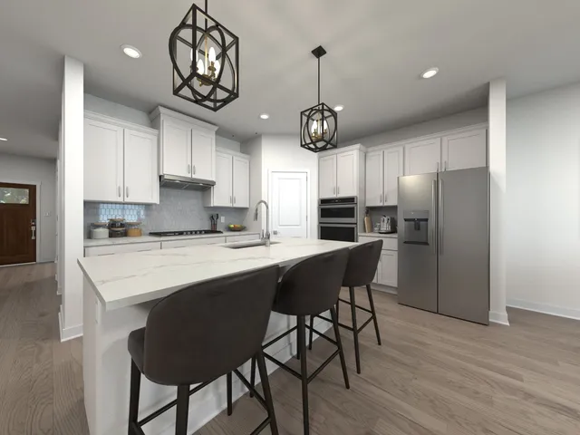 a kitchen with stainless steel appliances a dining table chairs stove refrigerator and cabinets