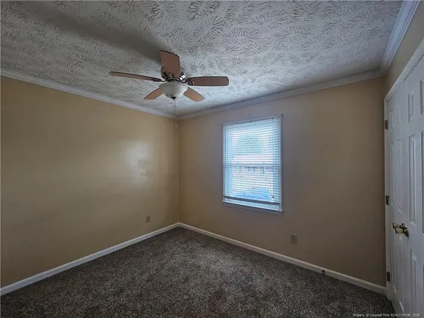 an empty room with a ceiling fan and window