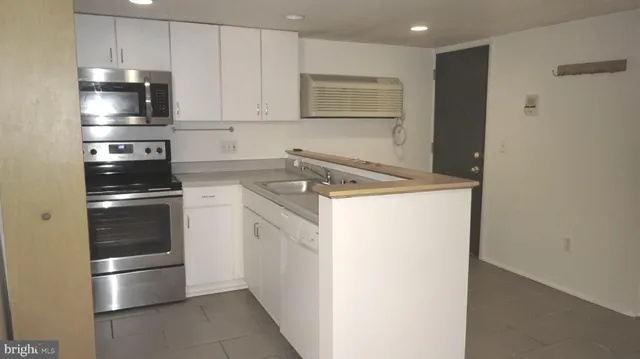 a kitchen with a refrigerator sink and cabinets